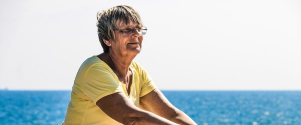 Older woman sitting on the beach